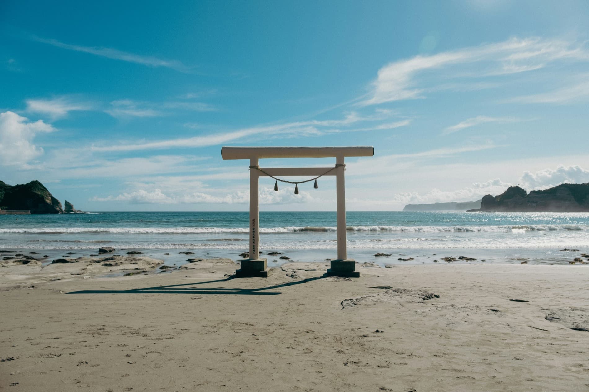 A torii gate standing on a Japanese beach